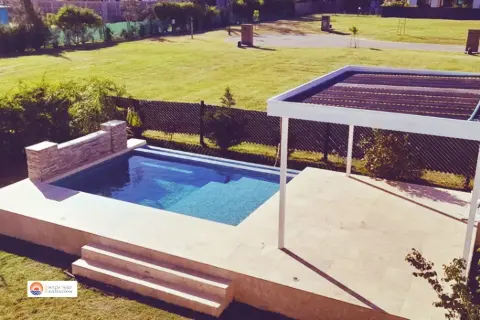 Pileta con colectores solares sobre una pérgola para calentar el agua