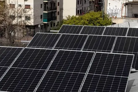 Arreglo de paneles solares sobre un techo, con edificios al fondo