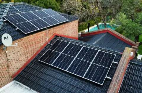 Paneles solares sobre dos techos de teja, vistos desde arriba
