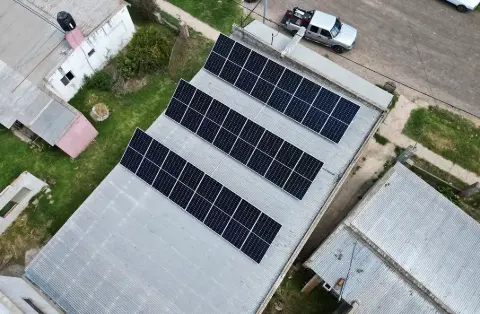 Tres filas de paneles solares sobre un techo de chapa, vistas desde arriba