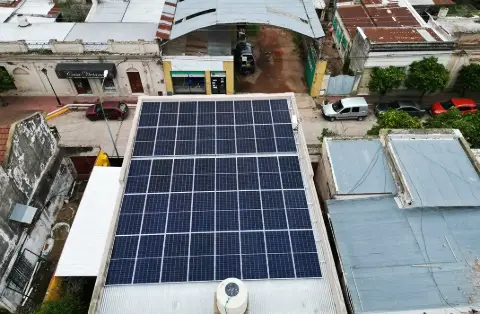 Vista aérea de un gran arreglo de paneles solares sobre el techo de un edificio comercial