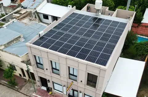 Paneles solares sobre el techo de un edificio de dos plantas, vista aérea