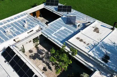 Paneles solares sobre techos planos alrededor de un patio interior, vista aérea