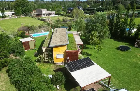 Paneles solares sobre el techo de un quincho en una casa de campo, vista aérea